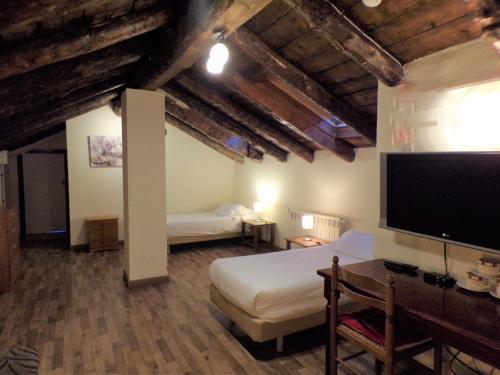 a bedroom with two beds and a flat screen tv at Hotel Roc de St Miquel & Apartment in Soldeu
