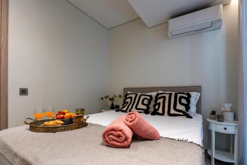 a bed with a bowl of fruit and towels on it at Evlalia home in Zakynthos Town