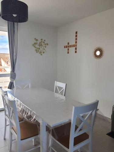 une table à manger blanche avec des chaises et une lampe dans l'établissement Appartement T3 Port-Leucate entre plage et port, à Port-Leucate