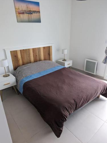 une chambre avec un grand lit avec deux tables de nuit dans l'établissement Appartement T3 Port-Leucate entre plage et port, à Port-Leucate