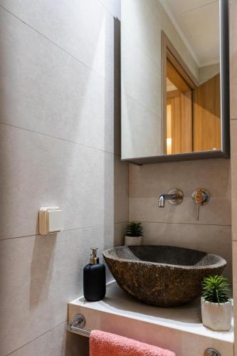 a bathroom with a stone sink and a mirror at Evlalia home in Zakynthos Town
