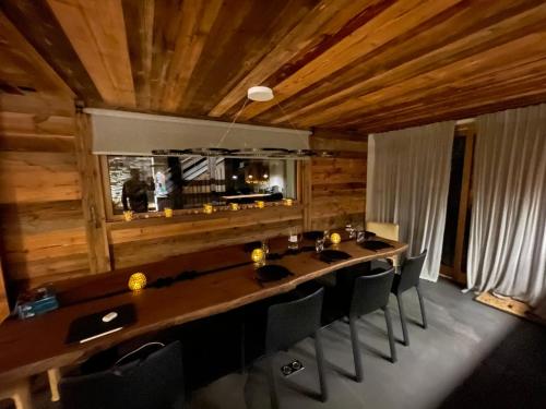 une salle à manger avec une grande table et des chaises en bois dans l'établissement Appartement Luxe comme un Chalet - vue exceptionnelle, à Combloux