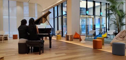 two people sitting at a piano in an office at Busan Station BOOKING THE BAY in Busan
