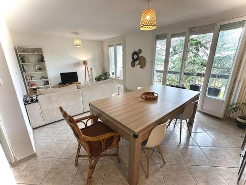 une salle à manger avec une table et des chaises en bois dans l'établissement Superbe, 3 chambres, au calme, parkings, à Décines-Charpieu