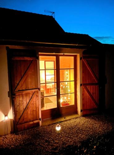a barn with a christmas tree in the window at Grande maison romantique avec jacuzzi intérieur & parking, à 1h30 de Paris in Montbouy