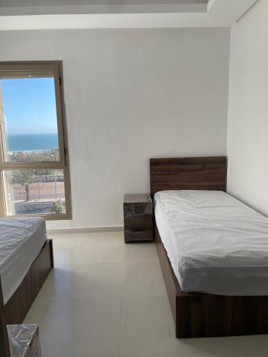 2 letti in una camera con finestra di Anza sahil Surf Appartement AGADIR ad Agadir