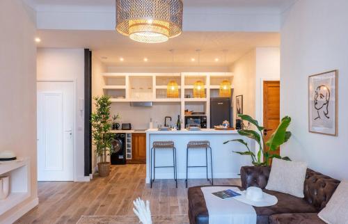 un salon avec un canapé et une cuisine dans l'établissement 65m2 Cosy 2 chambres - 10mn palais & plages, à Cannes