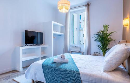- une chambre avec un lit et une serviette sur une table dans l'établissement 65m2 Cosy 2 chambres - 10mn palais & plages, à Cannes