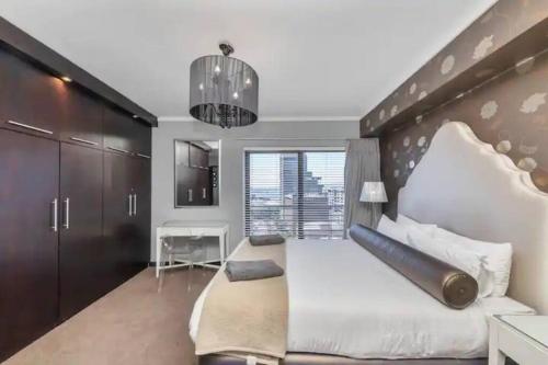 a bedroom with a large bed with a large wooden headboard at The Icon Capetown in Cape Town
