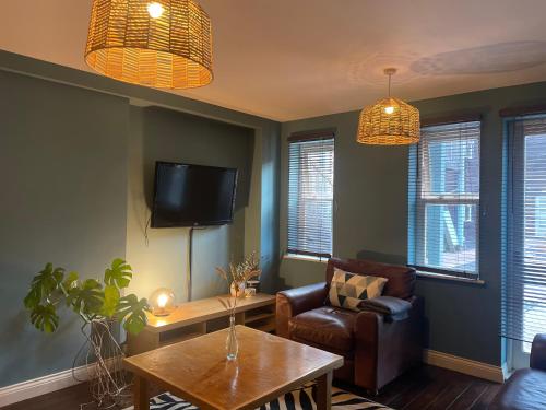 a living room with a couch and a table and a tv at 69D Victoria Street in Sheffield