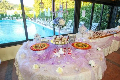 a purple table with food on it next to a pool at Le Naiadi Park Hotel Sul Lago in Bolsena