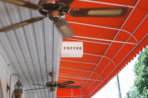 a red and white coffee sign hanging from a ceiling at Sidewalk Boutique Hotel in Ko Samed