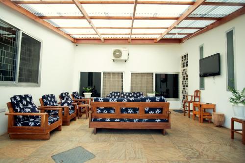 a large room with chairs and a flat screen tv at La Casa Preciosa in Tanga in Tanga