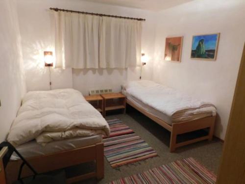 a bedroom with two beds and a table and two lamps at Chalet Silentium in Bellwald