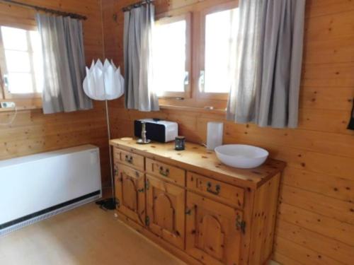 a bathroom with a sink and a tub and windows at Chalet Silentium in Bellwald