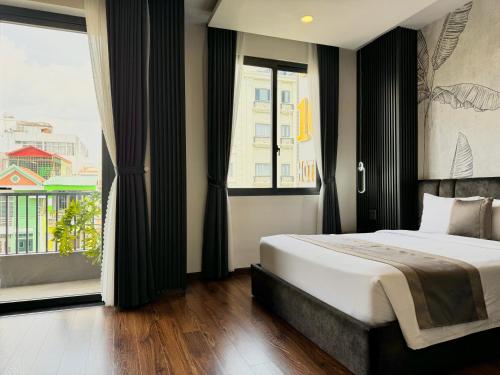 a bedroom with a bed and a large window at LION 10 HOTEL in Can Tho