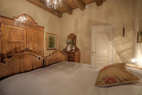a bedroom with a large bed with a wooden headboard at La Fornasaccia in Cesena
