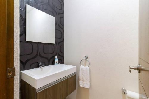 a bathroom with a white sink and a mirror at Casa para grupos grandes por el ITESO in Guadalajara