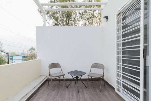 a patio with two chairs and a table on a balcony at Casa para grupos grandes por el ITESO in Guadalajara