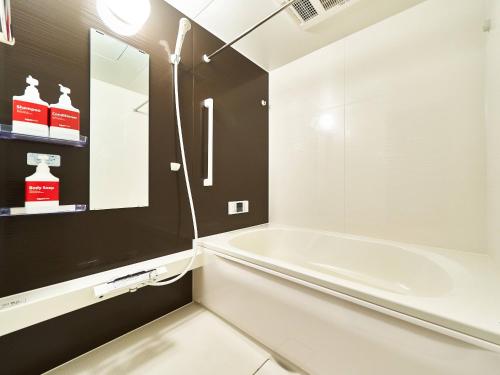 a bathroom with a white tub and a sink at Rakuten STAY HOUSE Kisarazu in Kisarazu