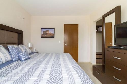 a bedroom with a large bed and a television at Casa para grupos grandes por el ITESO in Guadalajara