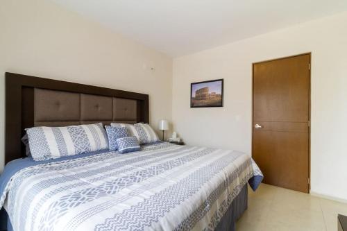 a bedroom with a large bed with blue and white pillows at Casa para grupos grandes por el ITESO in Guadalajara