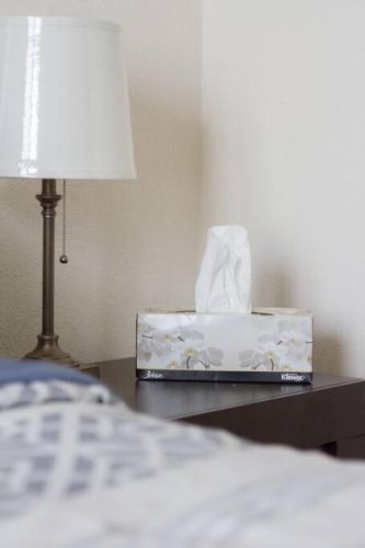 a bedside table with a box of tissues and a lamp at Casa para grupos grandes por el ITESO in Guadalajara