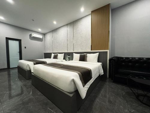 a bedroom with two beds and a couch in it at LION 9 HOTEL in Can Tho