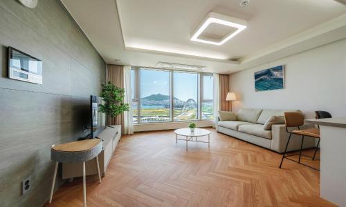 a living room with a couch and a tv at Busan Station BOOKING THE BAY in Busan