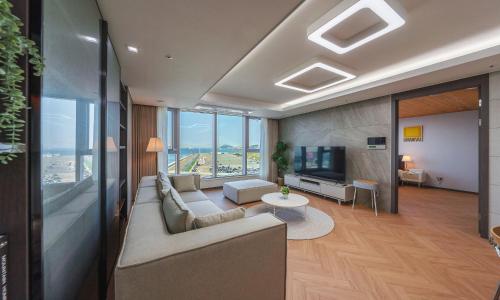 a living room with a couch and a tv at Busan Station BOOKING THE BAY in Busan