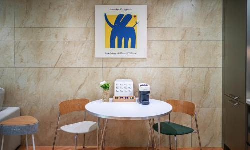 a table and chairs in a room with a picture on the wall at Busan Station BOOKING THE BAY in Busan