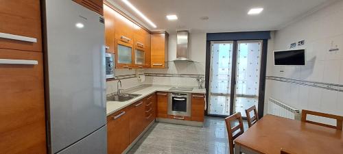 a kitchen with wooden cabinets and a sink and a table at Dúplex Luxury Alfaro in Alfaro
