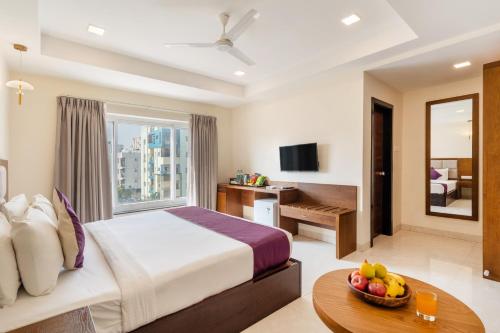 Una habitación de hotel con una cama y una mesa con un bol de fruta. en Destino by Monday Hotels Gachibowli, en Hyderabad