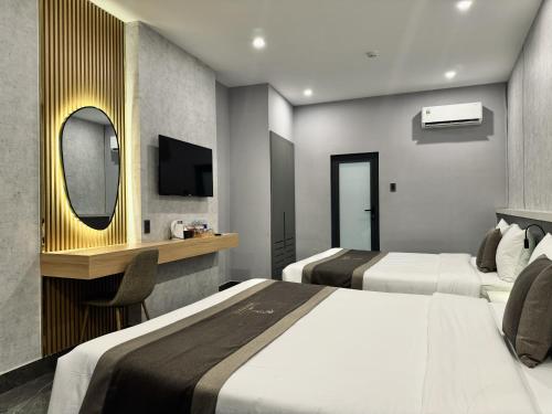 a hotel room with two beds and a mirror at LION 9 HOTEL in Can Tho