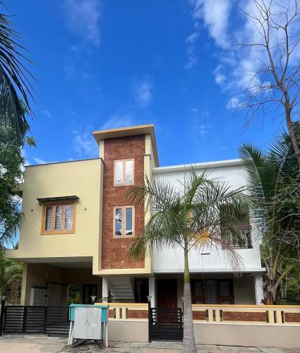 a building with a palm tree in front of it at Big Banyan Vineyard & Resort in Bengaluru