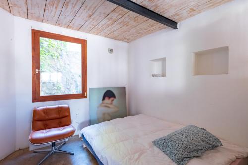 une chambre avec un lit, une fenêtre et une chaise dans l'établissement vue de rêve au vallon des auffes, 13007 marseille, à Marseille