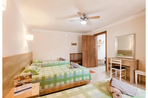 un dormitorio con una cama y un escritorio en Villa & Pool Apartments in Mellieha Bay, en Mellieħa
