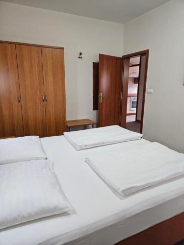 a bedroom with two beds and wooden cabinets at Dežman Apartments & Rooms in Kranj