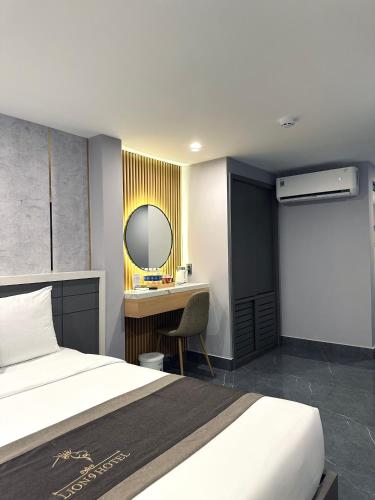 a bedroom with a bed and a desk with a mirror at LION 9 HOTEL in Can Tho