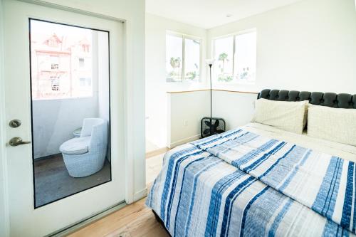 ロサンゼルスにあるUnique 3-Level Loft with One bedroom & Two Full Bathroomのベッドルーム1室(ベッド1台付)、窓際のトイレが備わります。