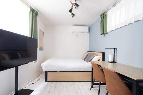 a bedroom with a desk and a bed and a table at ARM ikebukuro in Tokyo