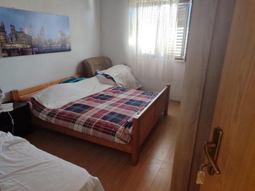 a small bedroom with two beds and a window at Apartments Nikola in Pučišća