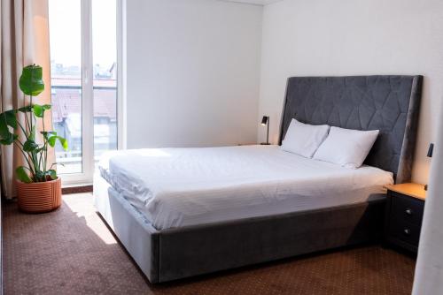 a bed in a bedroom with a large window at Thome Vlaicu170 Jacuzzi in Cluj-Napoca