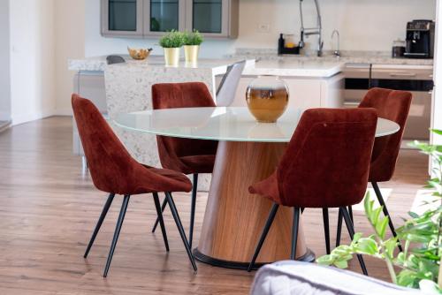 a kitchen with a glass table and four chairs at Thome Vlaicu170 Jacuzzi in Cluj-Napoca