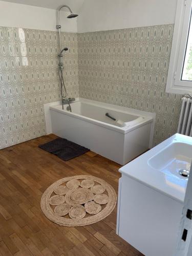 une salle de bain avec une baignoire et un lavabo dans l'établissement Agréable chambre, à Ussac