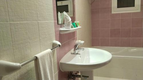 a bathroom with a sink and a bath tub at Al Massa Hotel Apartments 1 in Al Ain