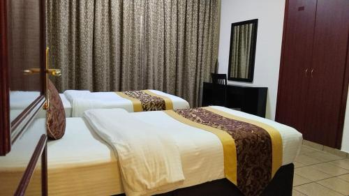 a hotel room with two beds and a window at Al Massa Hotel Apartments 1 in Al Ain
