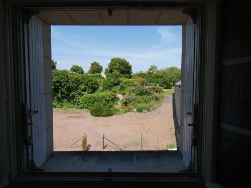 an open window with a view of a yard at Gîte Val de Loire L'instant famille in Saint-Léger-de-Montbrillais