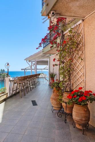 a patio with flowers in pots on the side of a building at Avra in Parga