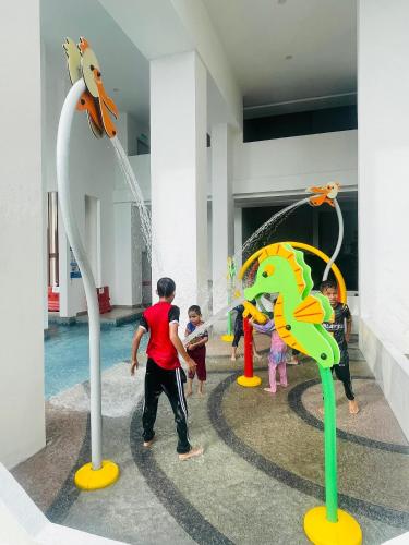 a group of children playing in a water park at HARRAZ SUITE PUTRAJAYA just minutes away from PICC and KPT perfect for both business and leisure stays in Putrajaya
